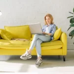 woman reading laptop on a couch